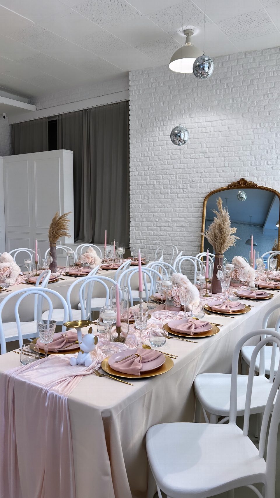 Tafel mit rosa Tischdeko und weißen Stühlen