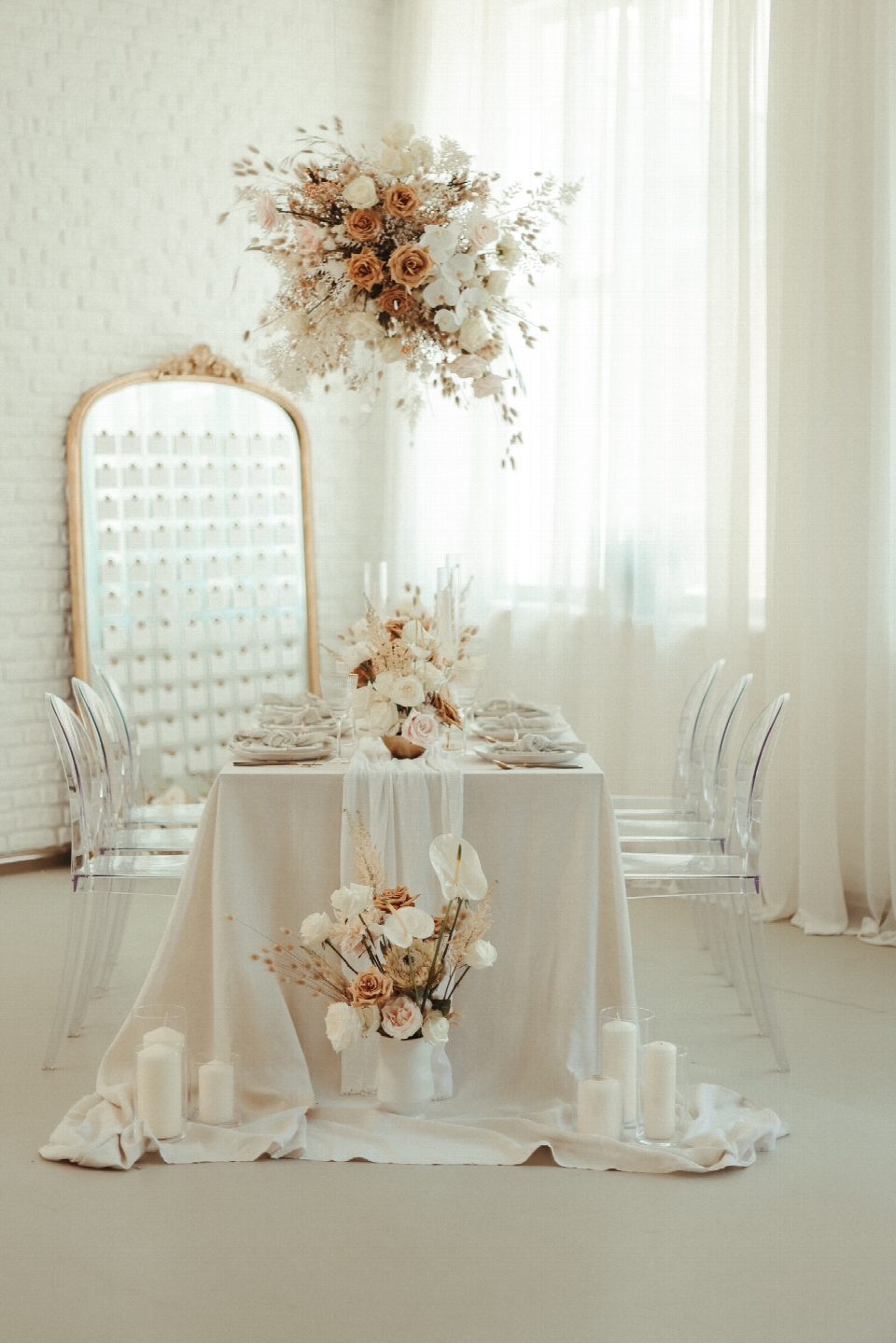 Gedeckter Tisch mit Blumen vor goldenem Spiegel